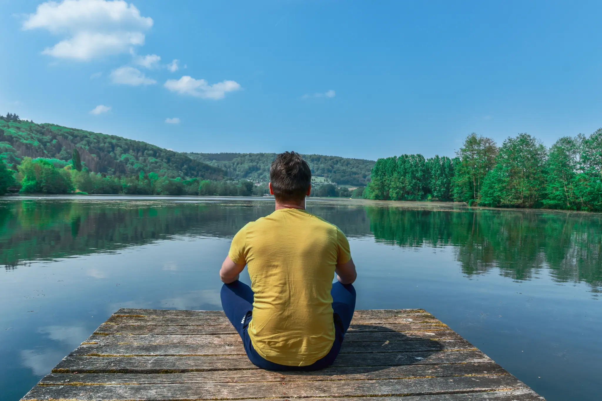 Person meditating on dock by lake — therapy for anxiety Los Angeles